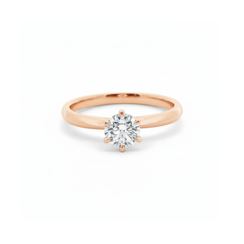 six-prong round diamond solitaire engagement ring in warm 18K rose gold — Diamond Ateliers.