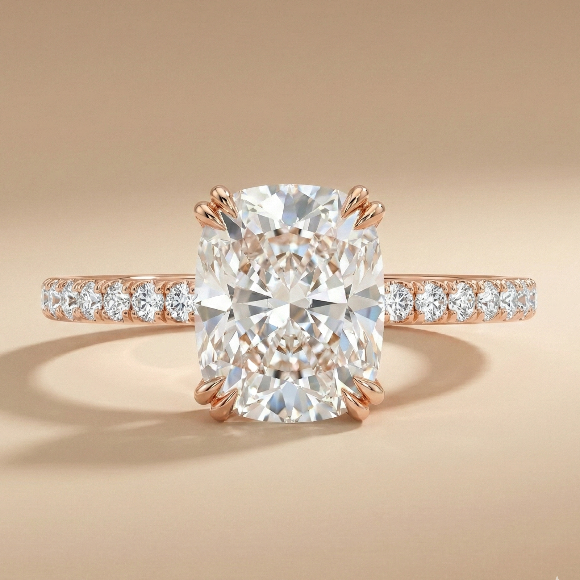 Cushion-cut diamond engagement ring in 18K rose gold with pavé diamond band and claw prongs.