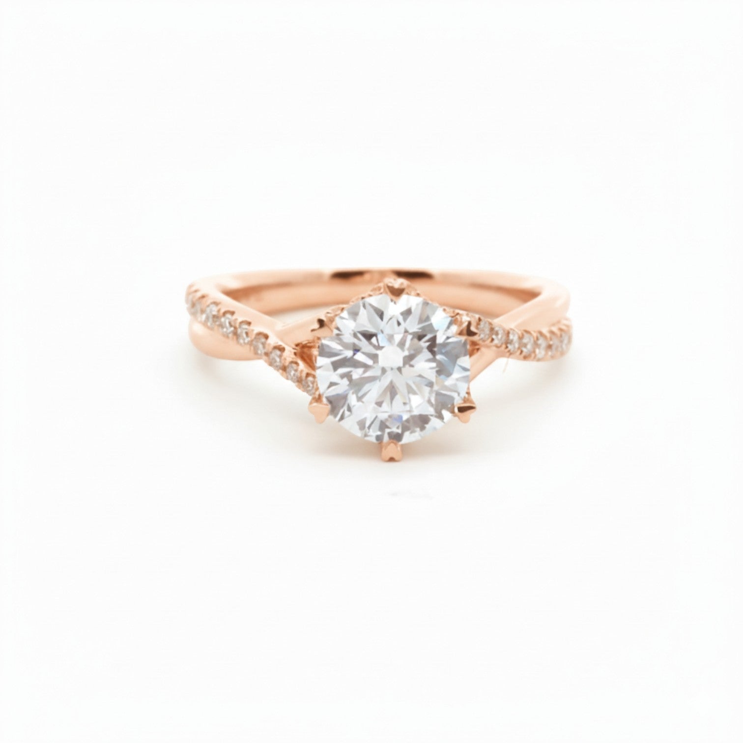 A twist-band solitaire engagement ring with 6 heart-shaped prongs in soft 18K rose gold — Diamond Ateliers.