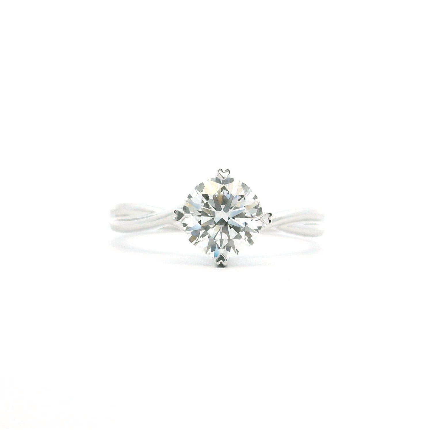 Classic high-polished twist solitaire with four heart-shaped prongs in 18K white gold – Diamond Ateliers.