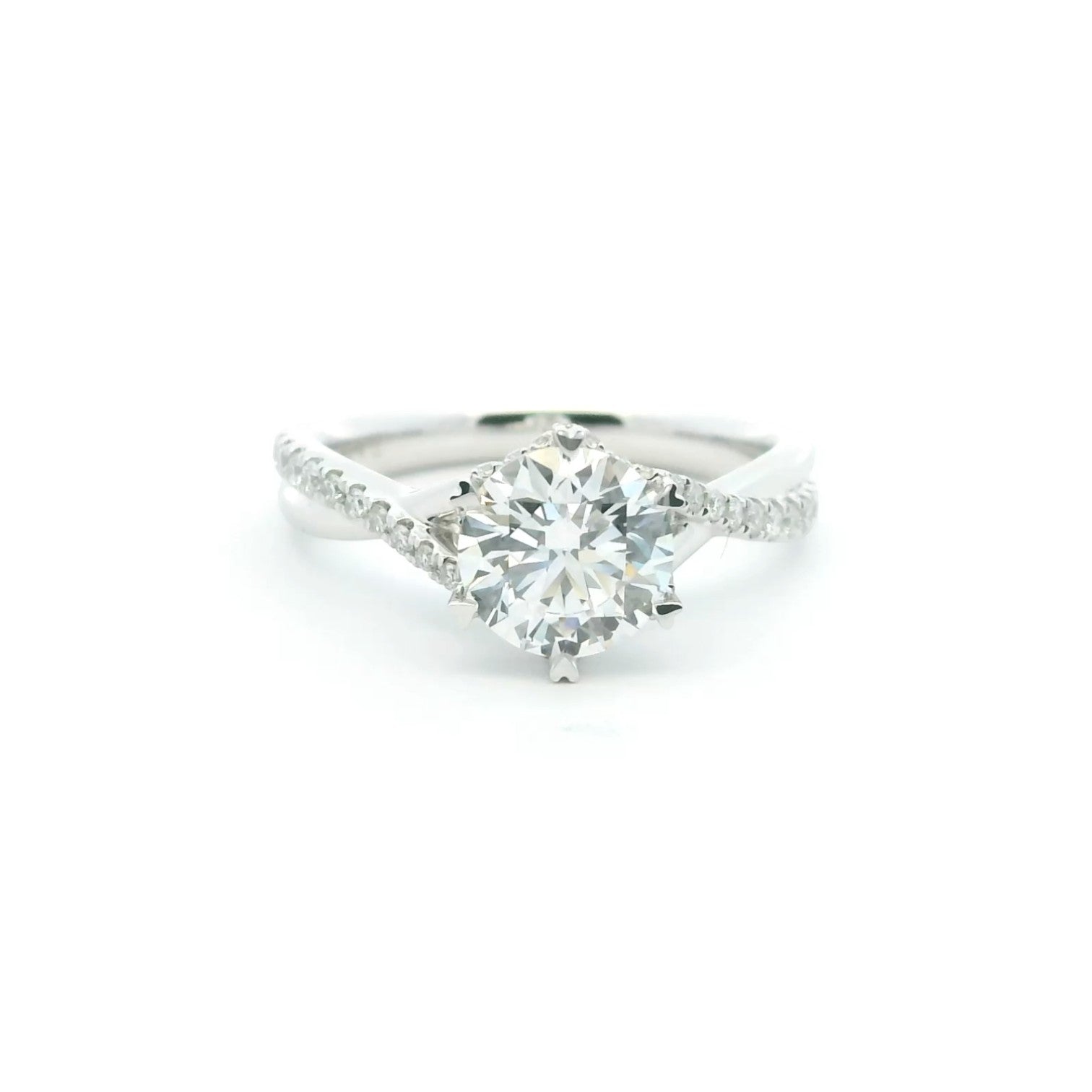A twist-band solitaire engagement ring with 6 heart-shaped prongs in polished 18K white gold — Diamond Ateliers.