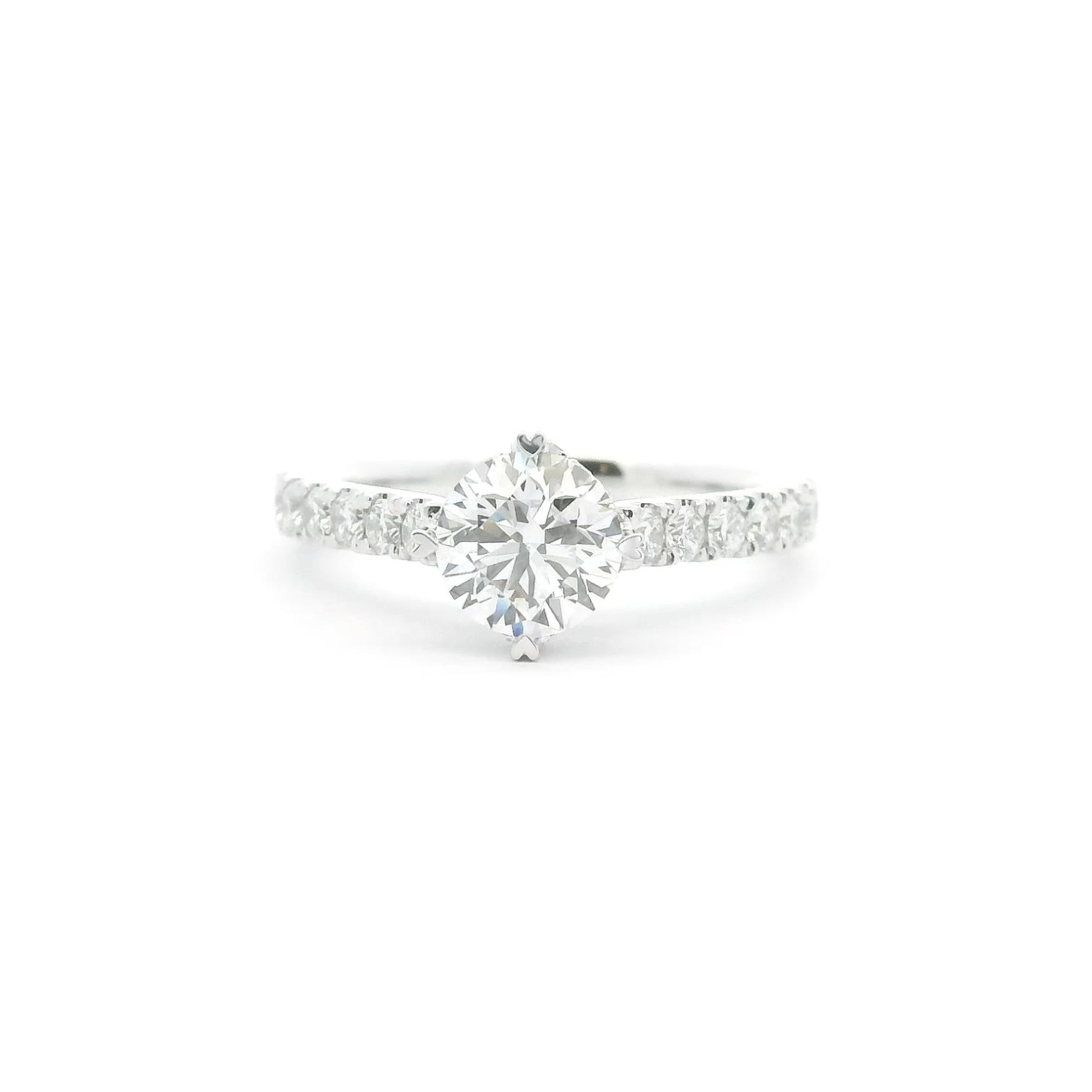 A pavé solitaire engagement ring with an NSEW setting and 4 heart prongs in 18K white gold — Diamond Ateliers.