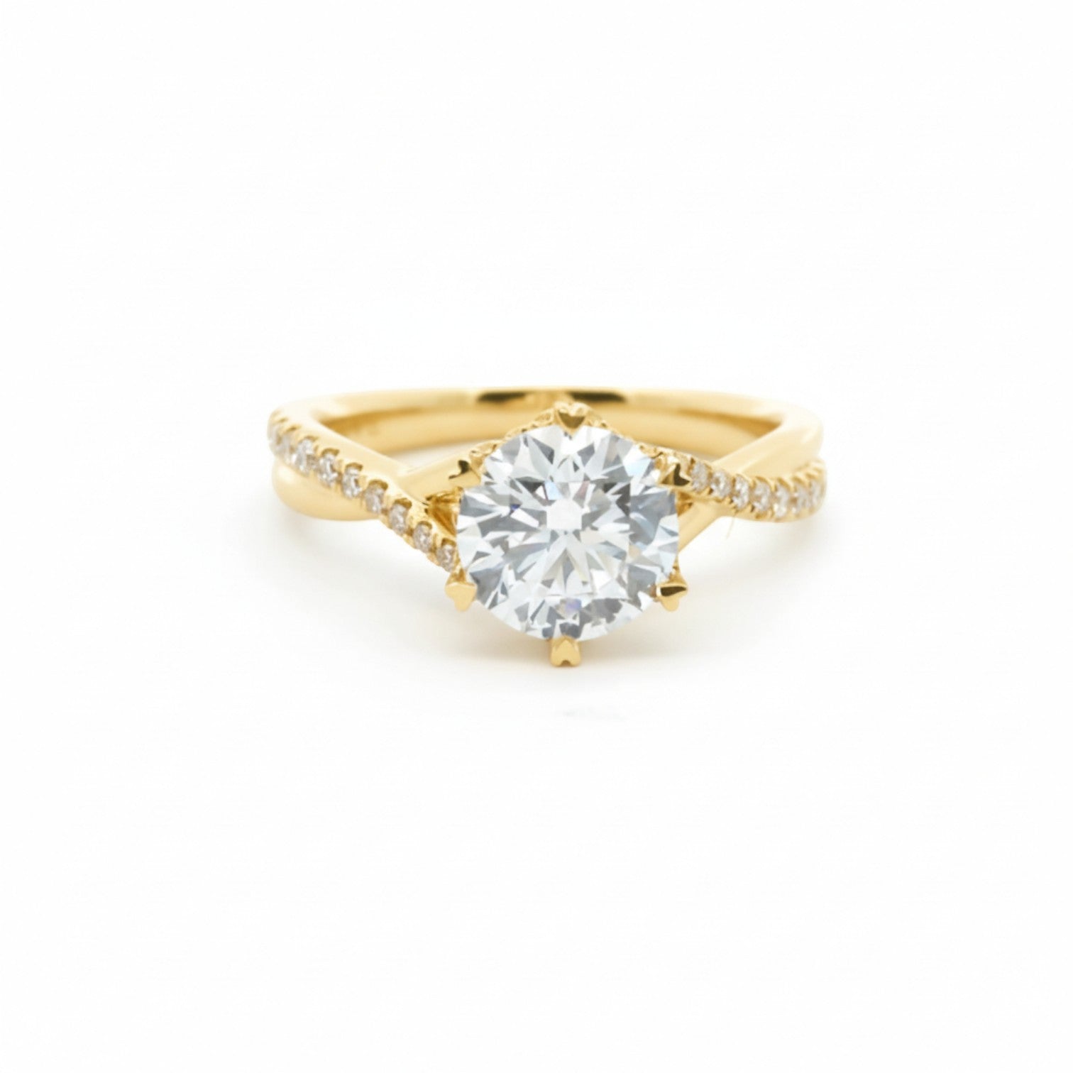 A twist-band solitaire engagement ring with 6 heart-shaped prongs in warm 18K yellow gold — Diamond Ateliers.