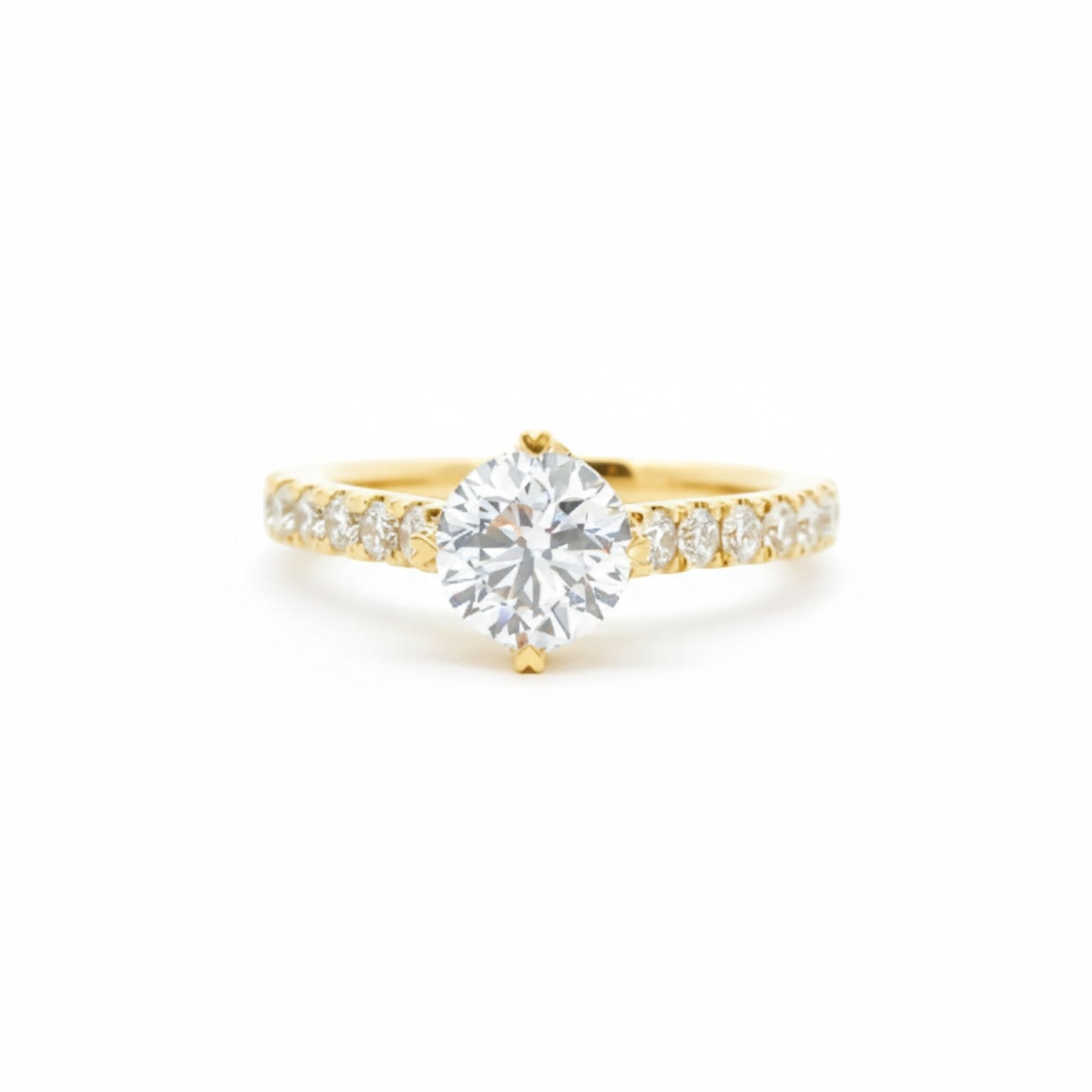 A pavé solitaire engagement ring with an NSEW setting and 4 heart prongs in 18K yellow gold — Diamond Ateliers.