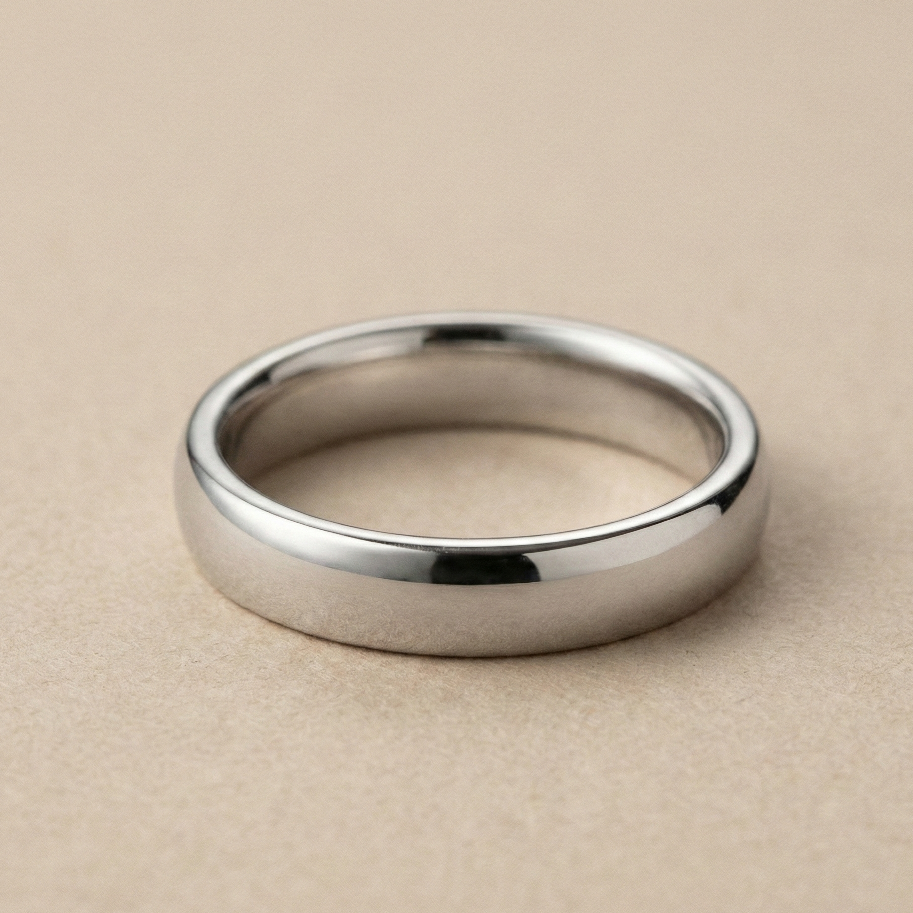 Platinum wedding band with a natural white sheen displayed on a smooth neutral background