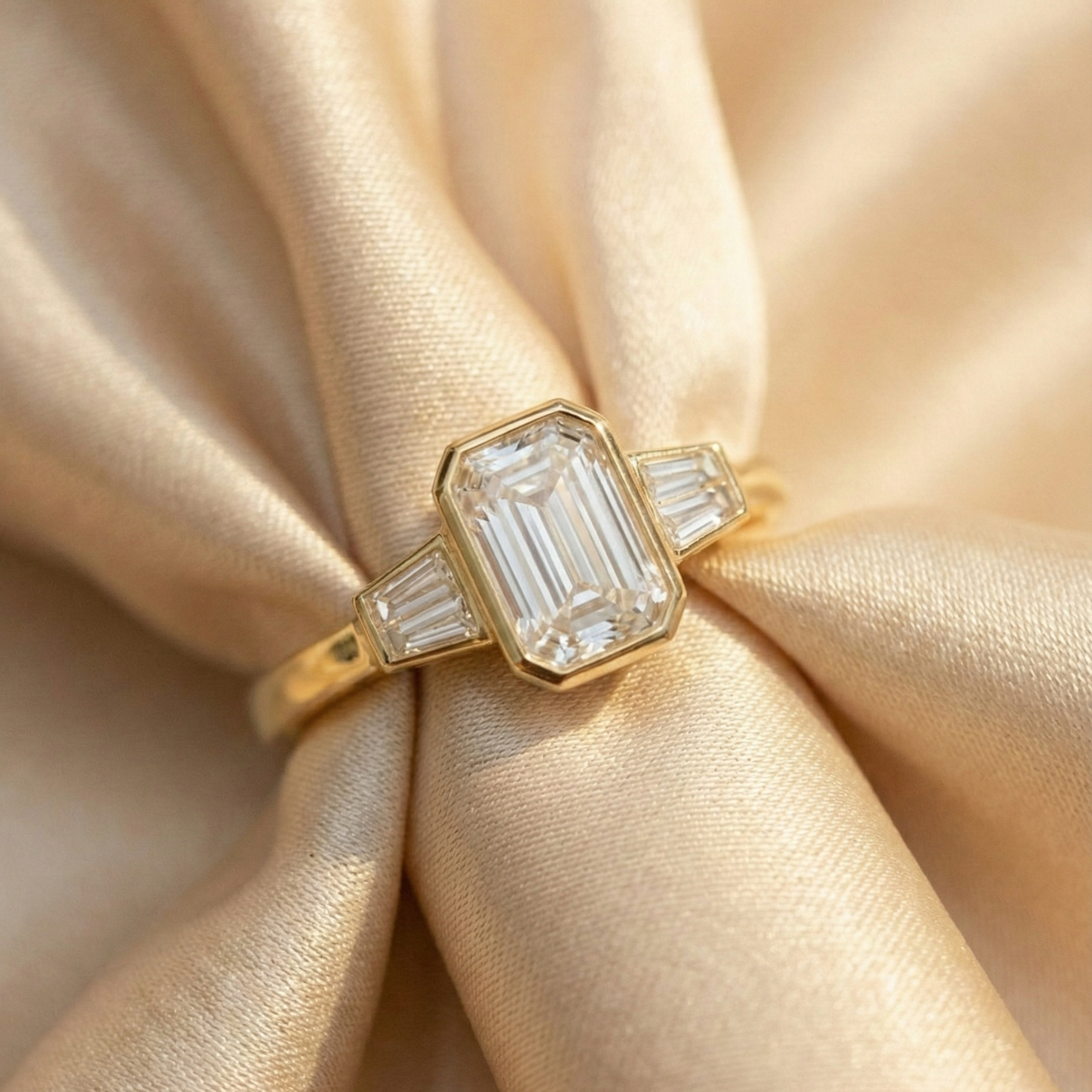 18k yellow gold emerald-cut engagement ring in a bezel setting, front view | Diamond Ateliers