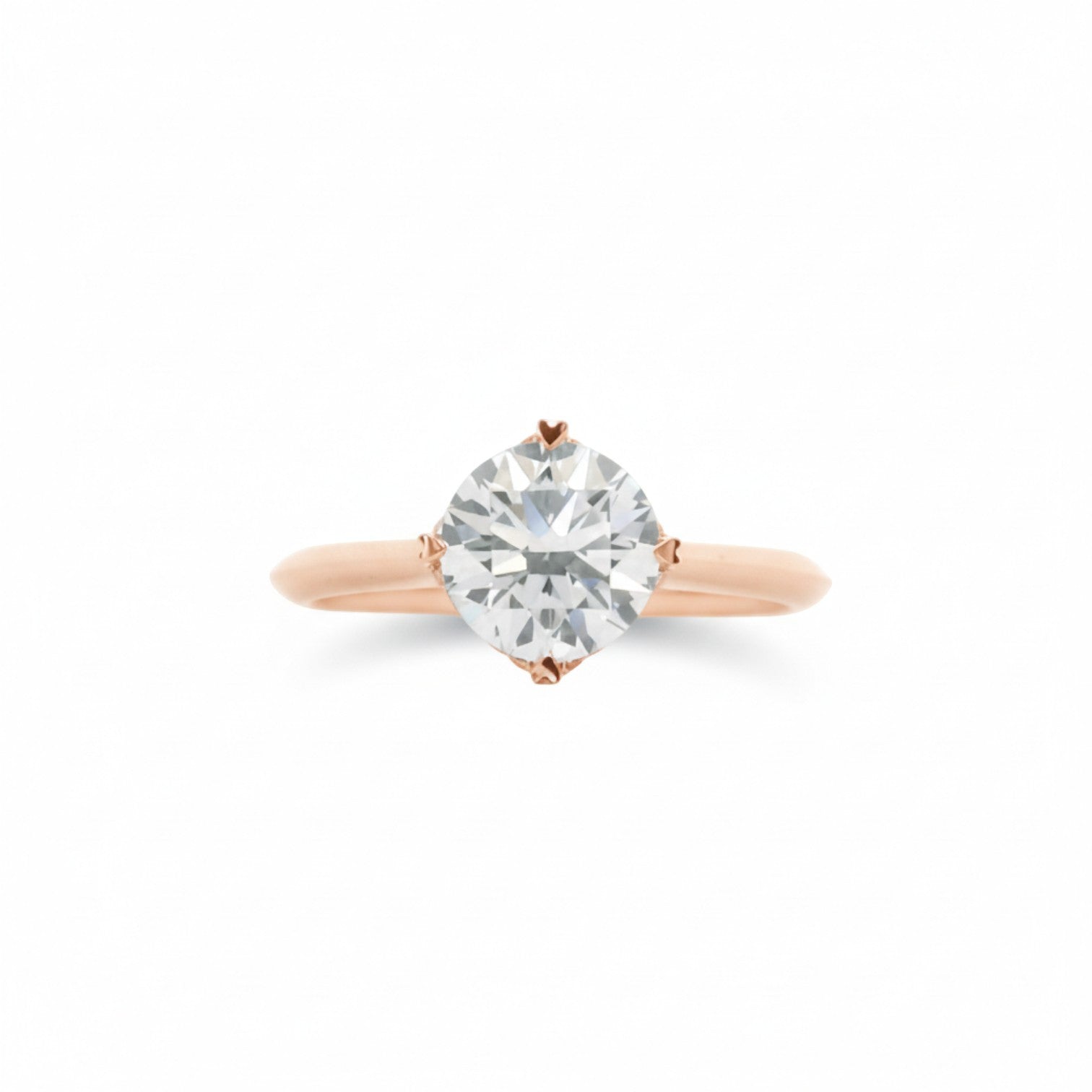 A NSEW solitaire engagement ring with 4 heart prongs in classic 18K Rose gold — Diamond Ateliers.