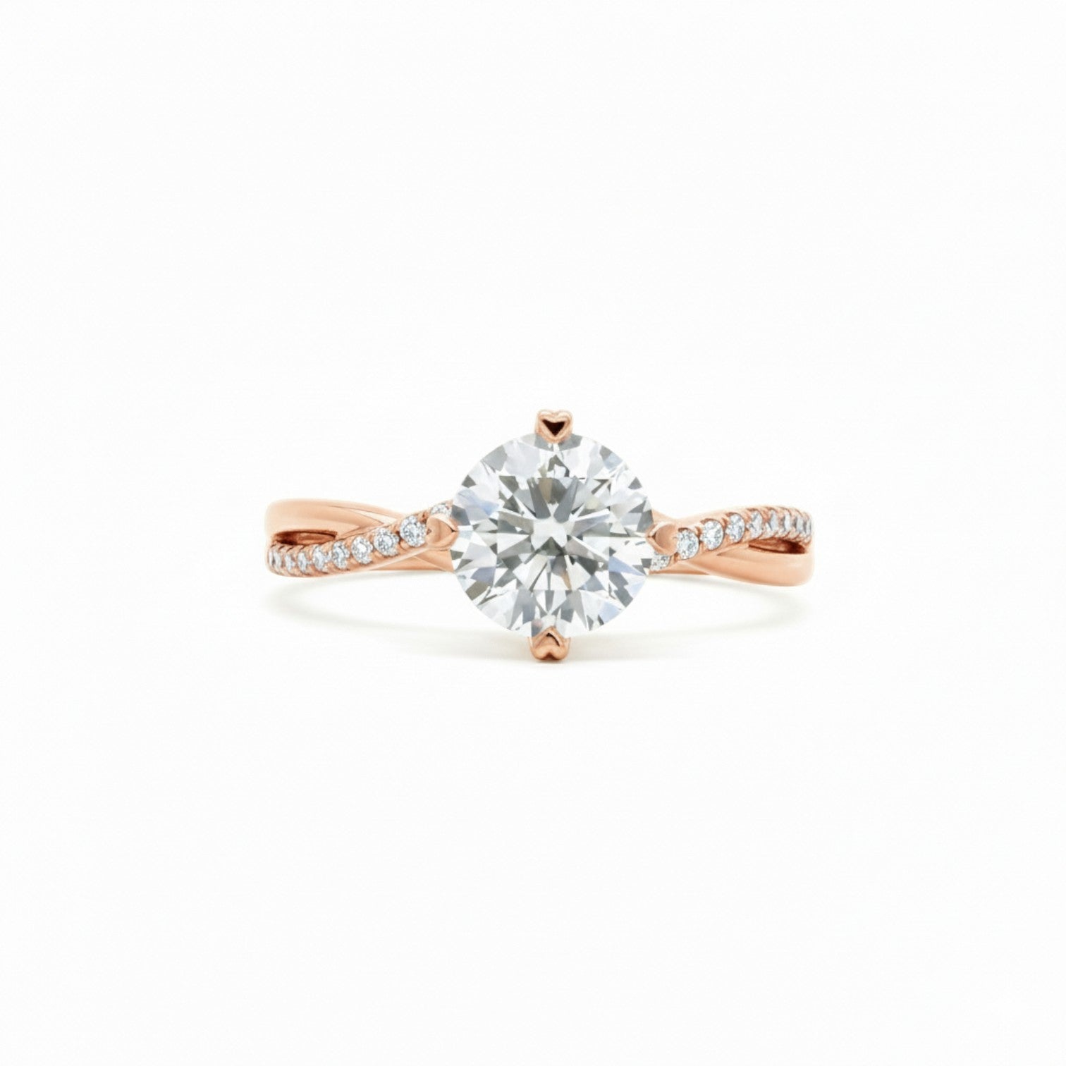 A twisted-band engagement ring with a round diamond and 4 heart prongs in warm 18K rose gold — Diamond Ateliers.