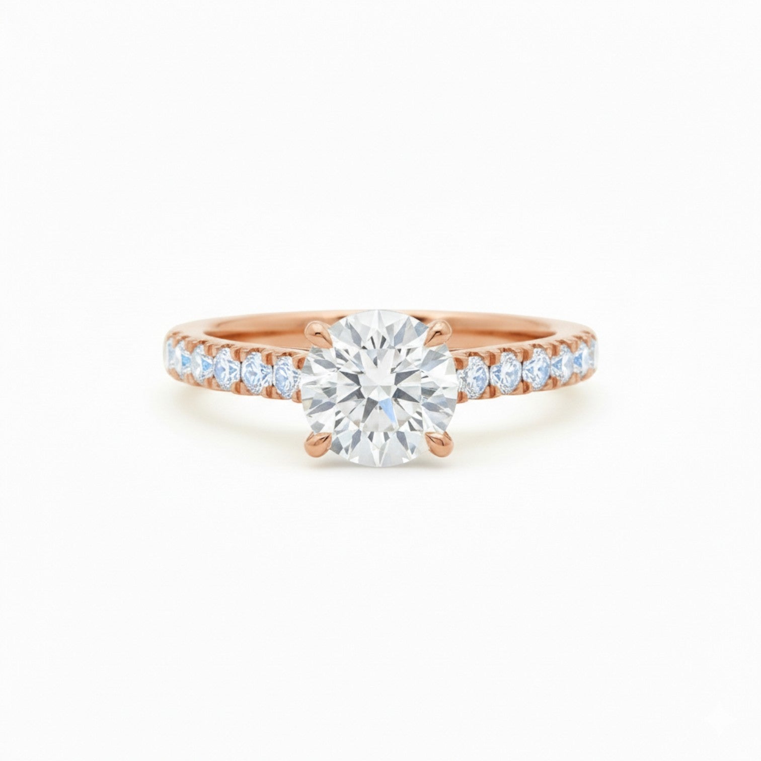 A four-prong claw pavé diamond engagement ring in warm 18K rose gold — Diamond Ateliers.