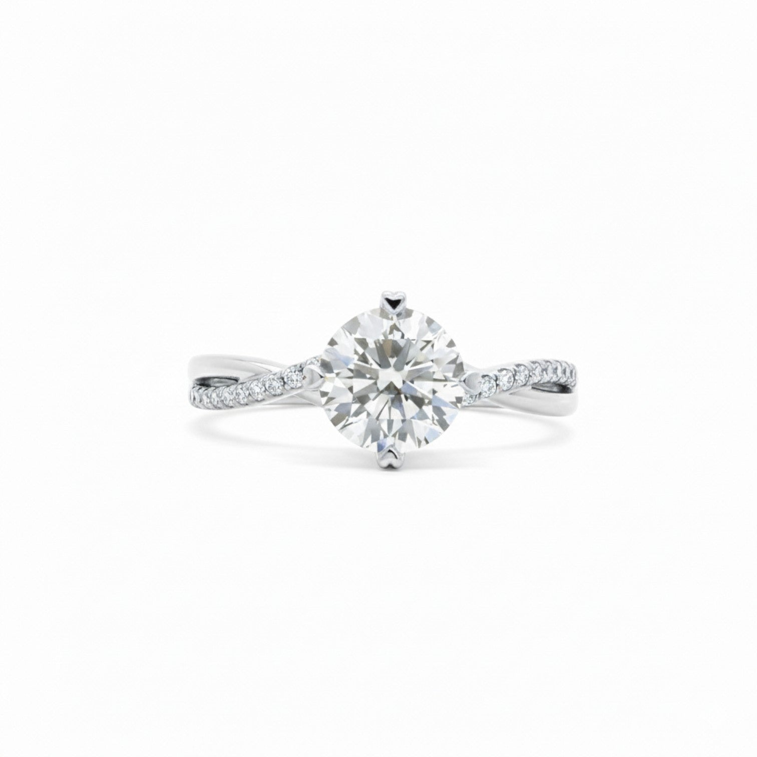 A twisted-band engagement ring with a round diamond and 4 heart prongs in polished 18K white gold — Diamond Ateliers.