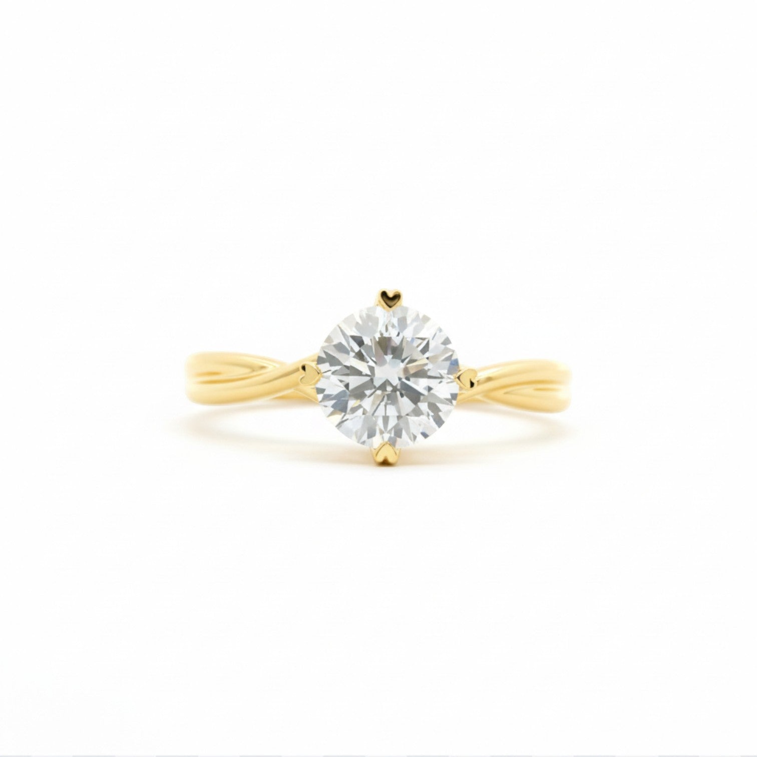 Classic twist solitaire with four heart-shaped prongs in 18K yellow gold – Diamond Ateliers.