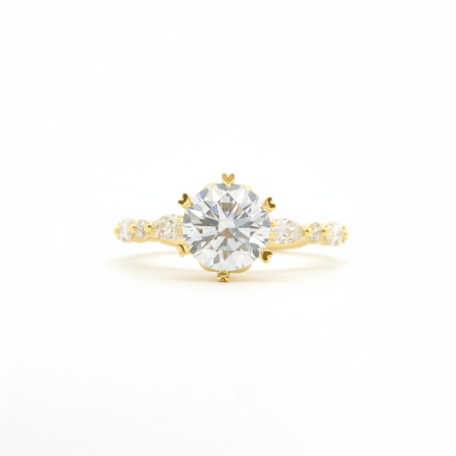 Round and marquise hybrid solitaire with six heart-shaped prongs in 18K yellow gold – Diamond Ateliers.