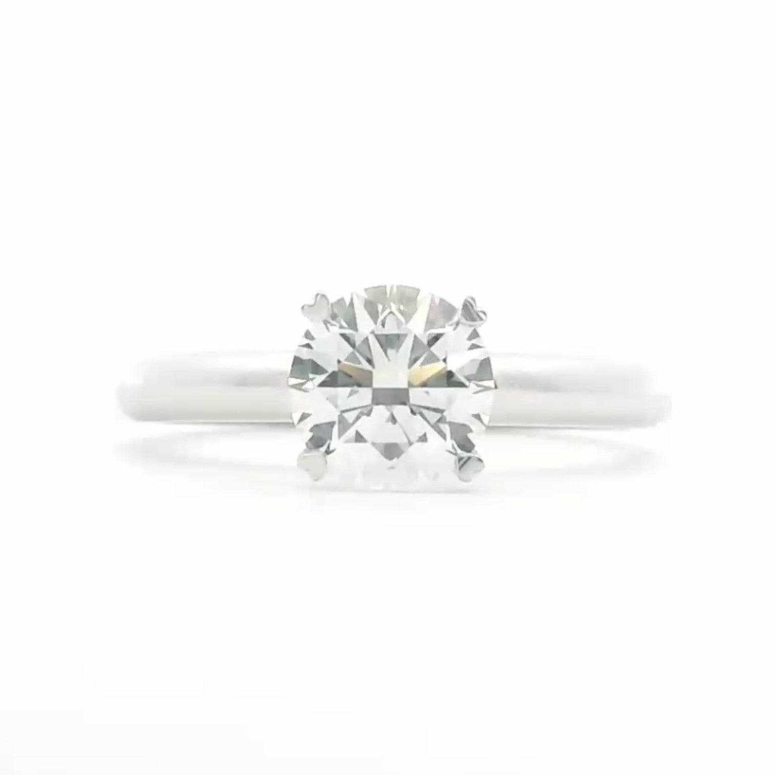 A classic solitaire engagement ring with 4 heart prongs in polished 18K white gold — Diamond Ateliers.