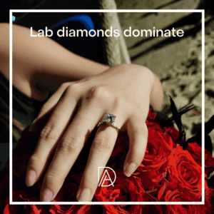 Close-up of a hand wearing a solitaire diamond ring with red roses in the background