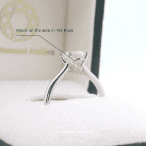 Top view of a bespoke engagement ring featuring heart-shaped prongs and a round diamond.