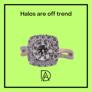 A cushion-cut diamond ring with a halo setting on a vibrant green background.